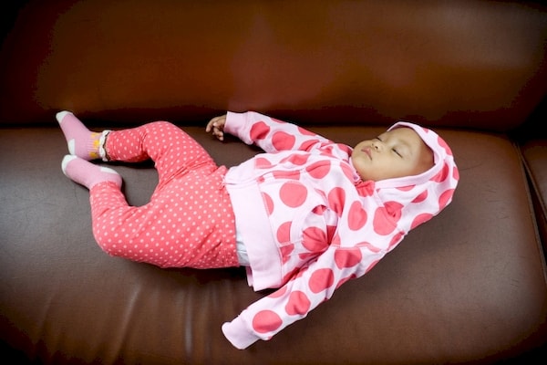 Infant napping on a sofa